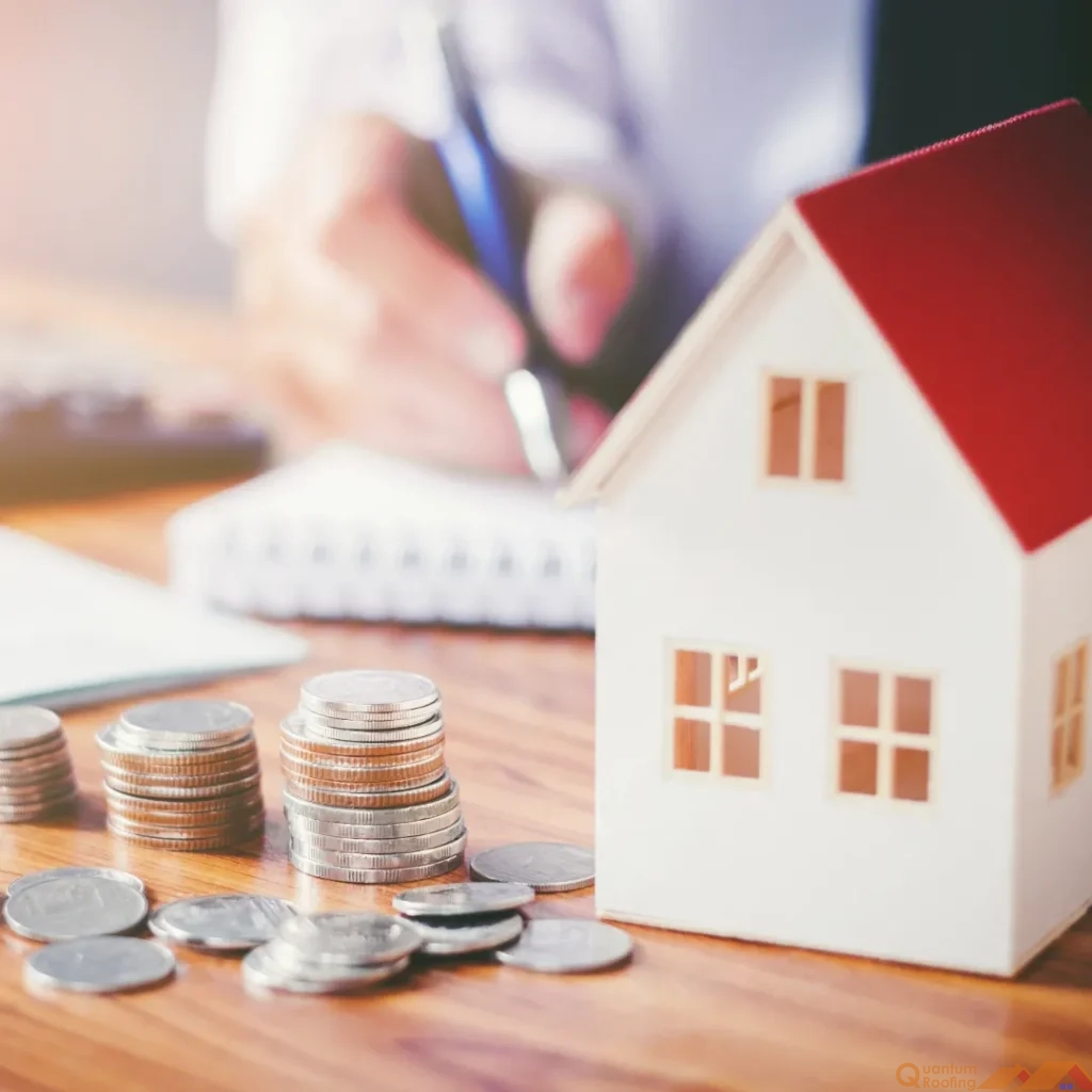 Cost of a roof replacement shown with a stack of coins and a small model house with a red roof.