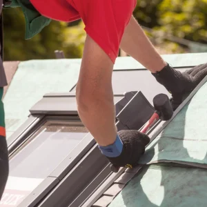 Roofing contractor performing skylight repair and flashing installation on South Carolina residential roof.