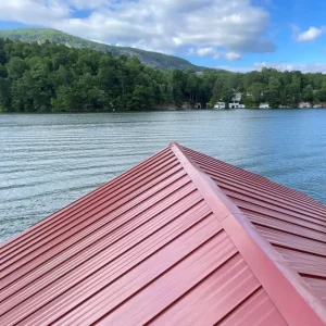 Red metal roof overlooking a lake and trees