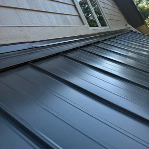 Metal roof in front of a window on a home.