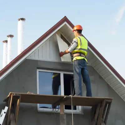 Image of a worker installing siding on a house