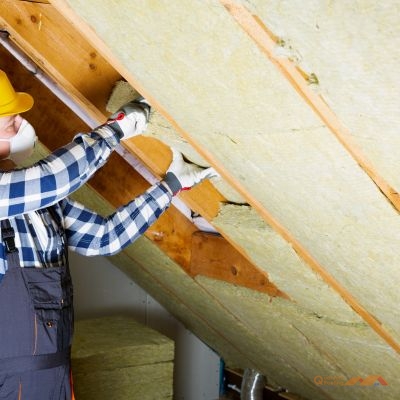 contractor installing attic insulation between rafters